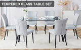 1 table and 6 light grey chairs. Glass dining table with black coated metal legs